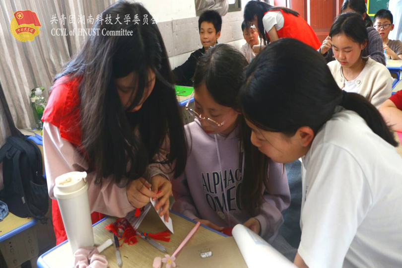 志愿者教学生剪纸.png