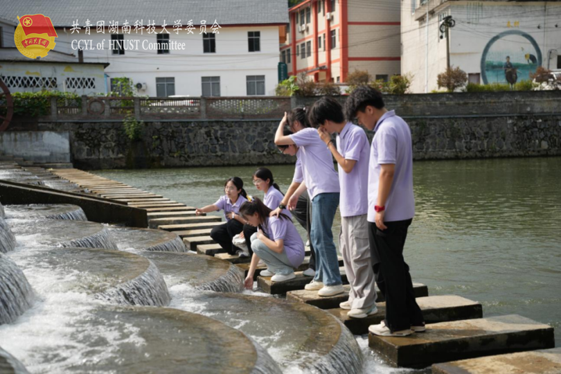 实践团成员对水坝进行实地设计考察.png