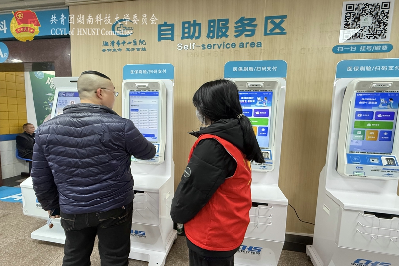志愿者引导患者使用自助服务设备.jpg